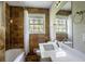 Bathroom with warm brown tiling, bright white shower curtain and window view at 1753 Dodson Sw Dr, Atlanta, GA 30311
