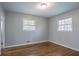 Bedroom with hardwood floors, gray walls, and two windows overlooking nature at 1753 Dodson Sw Dr, Atlanta, GA 30311
