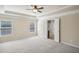 Bright bedroom featuring plush carpet, a ceiling fan, and a doorway leading to the bathroom at 5232 Centennial Hill Nw Dr, Acworth, GA 30102