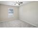 This bedroom features plush gray carpet, a ceiling fan, and a bright window at 5232 Centennial Hill Nw Dr, Acworth, GA 30102