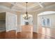 Open-concept dining room featuring hardwood floors, coffered ceilings, and an elegant chandelier at 5232 Centennial Hill Nw Dr, Acworth, GA 30102