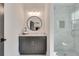 Bathroom vanity with a round mirror and a glass-enclosed shower featuring white subway tile at 2497 Sugar Pike Rd, Canton, GA 30115