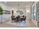 Bright dining room with a modern chandelier, round table with six chairs, and decorative window treatments at 2497 Sugar Pike Rd, Canton, GA 30115