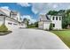 A long driveway extends past a white home into a matching detached garage with multiple parking spaces at 2497 Sugar Pike Rd, Canton, GA 30115