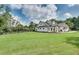 Sprawling lawn showcasing the home's modern farmhouse design, complemented by a classic black fence at 2497 Sugar Pike Rd, Canton, GA 30115