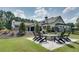 Charming outdoor living space with a stone fire pit and seating, complemented by the beautiful home exterior at 2497 Sugar Pike Rd, Canton, GA 30115