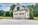 Two-car detached garage with black accents and carriage doors with a well-manicured lawn at 2497 Sugar Pike Rd, Canton, GA 30115