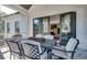 Screened in porch dining area with black metal table set and view into the gourmet kitchen through sliding glass door at 2497 Sugar Pike Rd, Canton, GA 30115