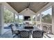 Beautiful screened porch with vaulted wood ceiling, ceiling fan, fireplace and outdoor lounge and dining furniture at 2497 Sugar Pike Rd, Canton, GA 30115