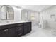 Modern bathroom with double sinks, dark cabinets, white marble countertops, and a glass-enclosed tiled shower at 3451 Keswick Ct, Atlanta, GA 30341