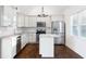 Well-lit kitchen features stainless steel appliances, white cabinets, an island and hardwood floors at 3451 Keswick Ct, Atlanta, GA 30341