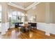 Elegant dining room with a round table, chandelier, and wainscoting, perfect for gatherings at 3999 Treemont Ln, Suwanee, GA 30024