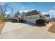 Home with a three-car garage and long driveway lined with bushes at 3999 Treemont Ln, Suwanee, GA 30024