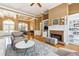 Warm living room with a fireplace, built-in shelving, and view into the dining area at 3999 Treemont Ln, Suwanee, GA 30024