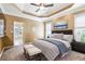 Relaxing main bedroom with a tray ceiling, plush carpet, and an ensuite bathroom at 3999 Treemont Ln, Suwanee, GA 30024