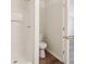 Small bathroom with a shower, toilet, and doorway to another room at 5537 Riverside Dr, Sugar Hill, GA 30518