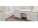 Bathroom with white vanity, sink, bathtub, and updated flooring at 5537 Riverside Dr, Sugar Hill, GA 30518