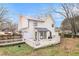 View of the back of a two-story house with white siding, black trim, and a deck at 9556 River Ct, Jonesboro, GA 30238