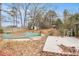 An in-ground swimming pool in a fenced backyard covered with a tarp and leaves at 9556 River Ct, Jonesboro, GA 30238