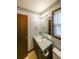 A bathroom with a single sink vanity, mirror, and decorative wallpaper border at 5065 Hubert Dr, Powder Springs, GA 30127