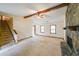 Bright living room with a stone fireplace, exposed beam, neutral carpet, stairs, and natural light at 5065 Hubert Dr, Powder Springs, GA 30127