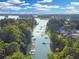 An aerial view showcasing docks along a waterway surrounded by lush greenery and scattered homes at 7360 Fields Dr, Cumming, GA 30041