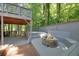 Outdoor fire pit area with built-in seating and adjacent to the upper level outdoor deck at 7360 Fields Dr, Cumming, GA 30041