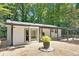 Charming single story home showing a backyard with a stone patio and pergola-covered outdoor seating area at 7360 Fields Dr, Cumming, GA 30041