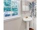 Bright bathroom features a pedestal sink, a window with natural light, and a stylish shower curtain at 7360 Fields Dr, Cumming, GA 30041