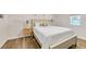 Bright and airy bedroom featuring a queen size bed, wood floors, a nightstand, and a window at 7360 Fields Dr, Cumming, GA 30041
