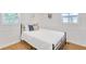 Cozy bedroom with a full bed, wood floors, white wainscoting and modern decor at 7360 Fields Dr, Cumming, GA 30041