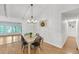 Bright dining room features a chandelier, wood floors, and seating for four at 7360 Fields Dr, Cumming, GA 30041