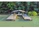 View of a covered dock with a yellow kayak; green trees line the background at 7360 Fields Dr, Cumming, GA 30041
