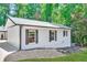 Single-story home with black trim offers a clean and modern look, surrounded by lush greenery and a driveway at 7360 Fields Dr, Cumming, GA 30041