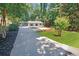 Inviting single-story house with a long driveway surrounded by lush greenery and well maintained lawn at 7360 Fields Dr, Cumming, GA 30041
