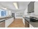 Contemporary kitchen featuring white cabinets, stainless steel appliances, and wood floors at 7360 Fields Dr, Cumming, GA 30041