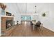 Open concept living room and dining area features brick fireplace and wood floors at 7360 Fields Dr, Cumming, GA 30041