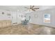 Bright open living room features tile flooring, a ceiling fan, a dining table, a kitchenette, and natural light at 7360 Fields Dr, Cumming, GA 30041