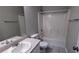 This bathroom features a shower and tub combination, a single sink vanity, and neutral tile flooring at 1343 Willow Sw Trl, Atlanta, GA 30311
