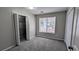 This bedroom includes neutral paint, plush carpeting, a window, and a closet for ample storage at 1343 Willow Sw Trl, Atlanta, GA 30311