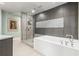 Bathroom with a modern shower, soaking tub, and gray tile walls with decorative accents at 2881 Peachtree Ne Rd # 1001, Atlanta, GA 30305