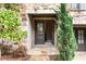 Charming townhome entrance features a stone facade, double doors, and lush greenery, creating an inviting entryway at 6657 Encore Blvd, Atlanta, GA 30328