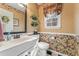 Charming half bathroom with floral wallpaper, a decorative mirror, and a white vanity sink at 154 Hunters Trl, Dallas, GA 30157