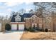 Traditional brick home featuring a two-car garage, black shutters, and a well-manicured front yard at 154 Hunters Trl, Dallas, GA 30157