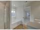 A bright bathroom featuring a separate shower and tub next to an open doorway to a bedroom at 325 Heavenly Hollow Pl, Mcdonough, GA 30253