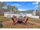 Backyard fire pit with seating surrounded by a pool, deck, and white wooden beams at 4087 Glenn Rd, Powder Springs, GA 30127