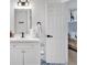 Bright bathroom featuring a large mirror, white vanity, and black hardware, adjacent to the bedroom at 4087 Glenn Rd, Powder Springs, GA 30127