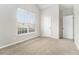 Cozy carpeted bedroom with two doors, a large window that offers exterior views, and neutral paint at 503 Goldfinch Way, Stockbridge, GA 30281