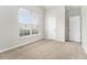 Bedroom showcasing neutral walls, carpeted floors, a window with blinds, and a view into the neighborhood at 503 Goldfinch Way, Stockbridge, GA 30281