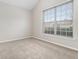 Bright bedroom with neutral carpet and walls featuring a large window with neighborhood views at 503 Goldfinch Way, Stockbridge, GA 30281